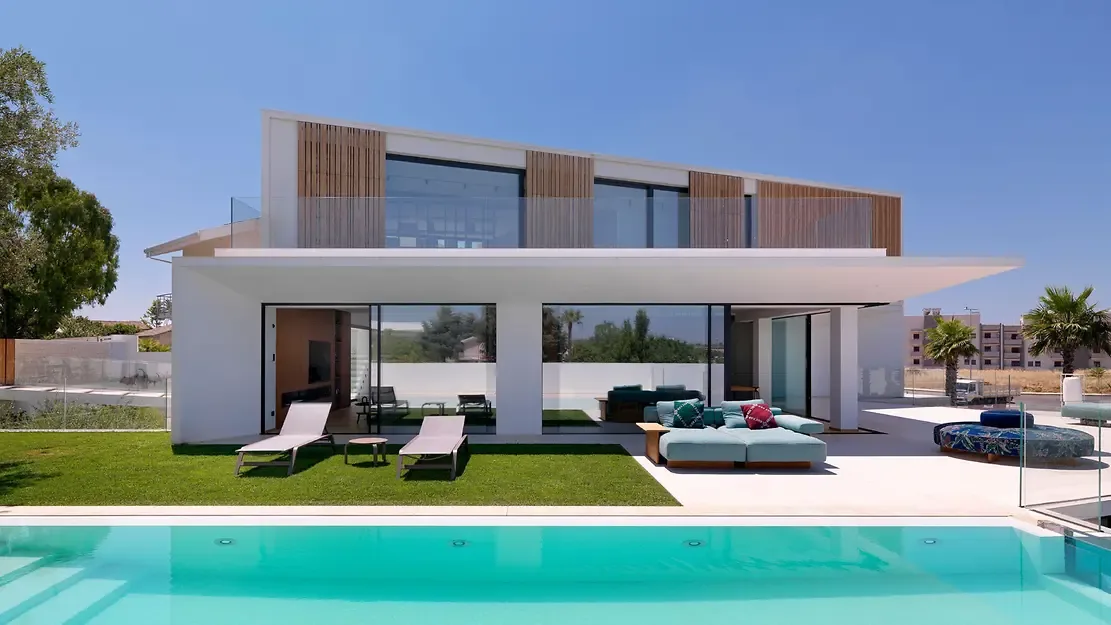 Schüco panoramic sliding glass doors on a modern villa with pool