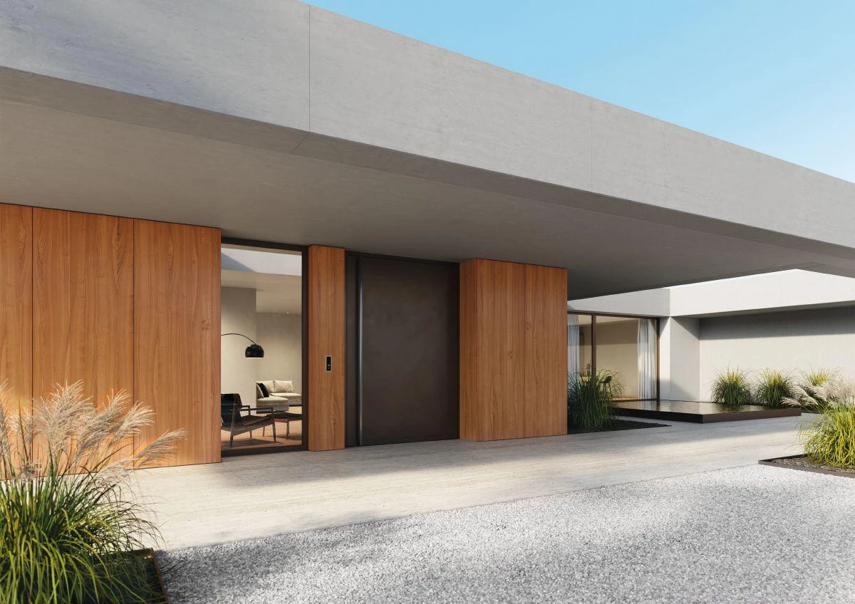 Large flush aluminum pivot entrance integrated into a modern wood and concrete facade