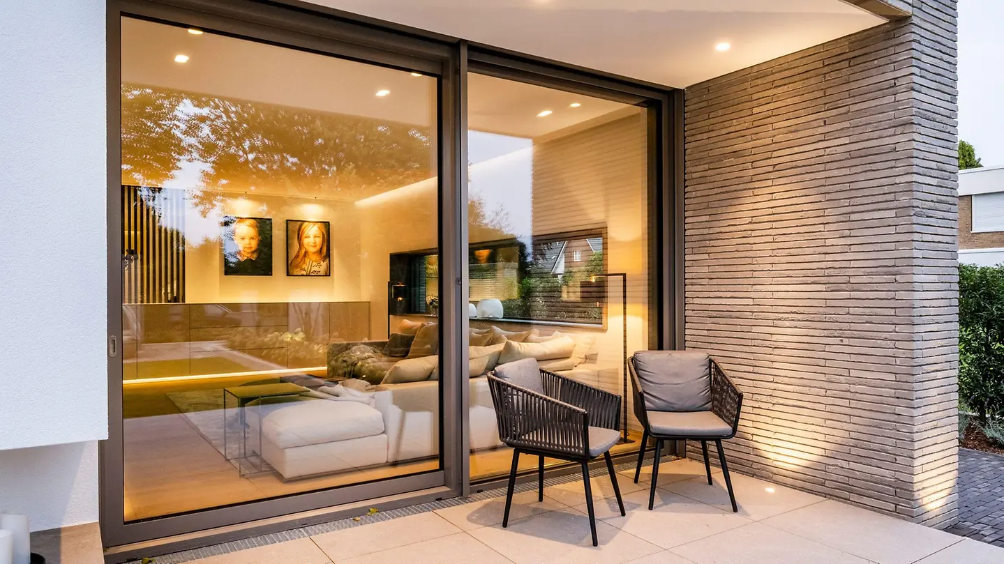 Close view of Schüco ASE 80 sliding doors beside a terrace