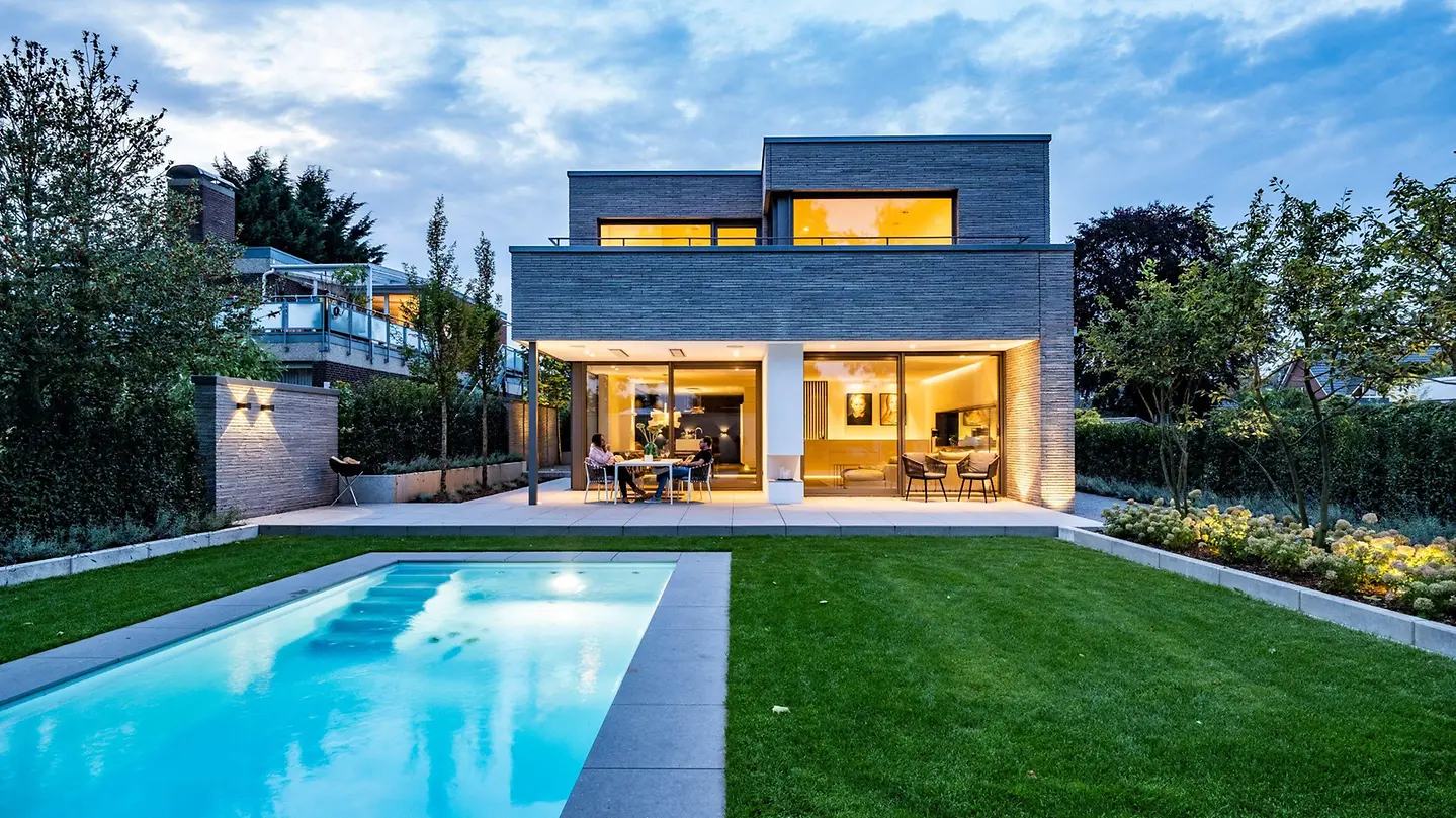 Contemporary home with Schüco ASE 80.HI sliding doors facing a pool